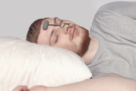 Ein Mann schläft mit einem elektronischen Pflaster auf Stirn und Nase.
