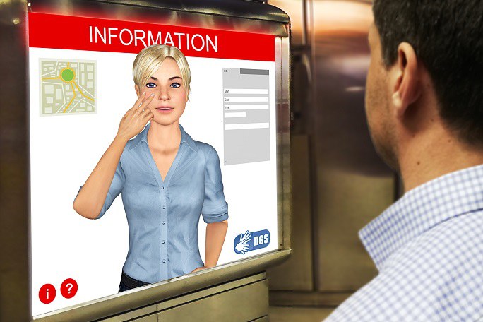 Ein Mann steht vor einem Bildschirm, auf dem der Avatar einer jungen blonden Frau abgebildet ist, die in Gebärdensprache kommuniziert.