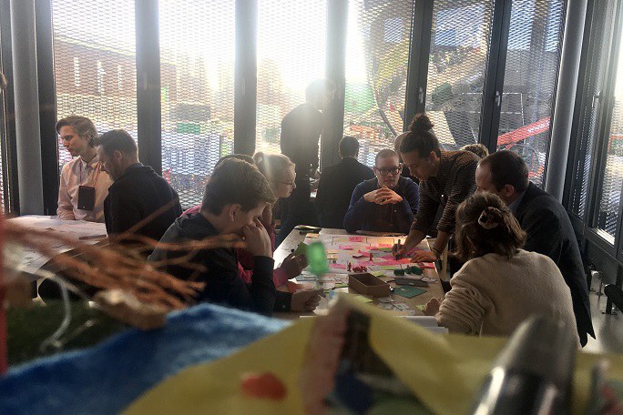 Eine Gruppe von Menschen arbeitet gemeinsam kreativ an einem Tisch