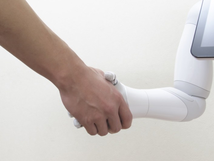 Eine Roboterhand schüttelt eine Menschenhand.
