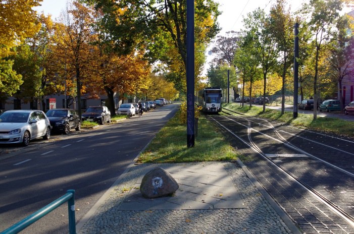 Eine Straße mit Autos und eine Straßenbahn. 