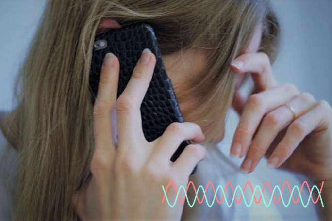 Eine Frau telefoniert mit dem Handy und hält sich dabei die Hand an die Stirn. Im Vordergrund sind Sinuswellen abgebildet.