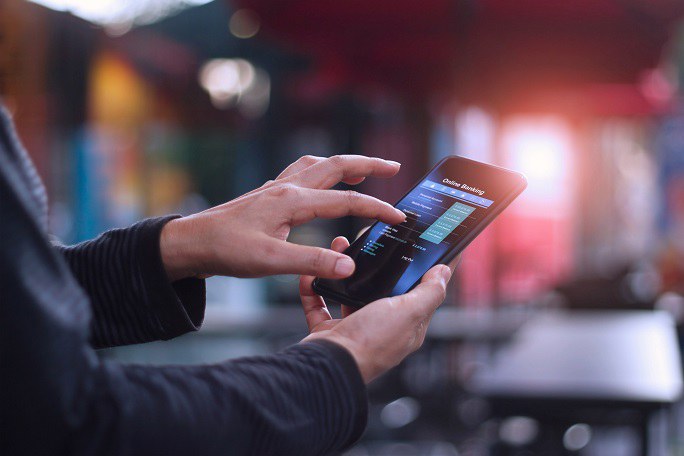 Eine Person interagiert mit einer Online-Banking-App auf dem Smartphone.