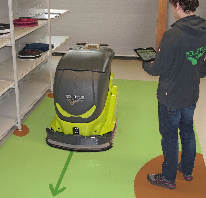 Reinigungsroboter, Pfeil auf Boden zeigt Richtung