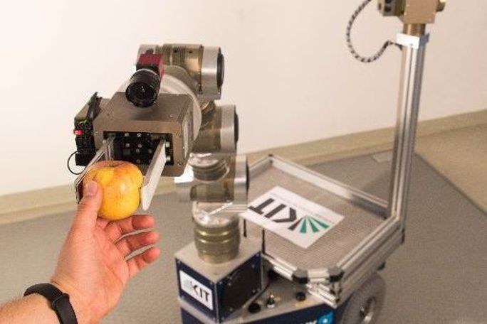 Ein Roboter, der einen Apfel reicht. 