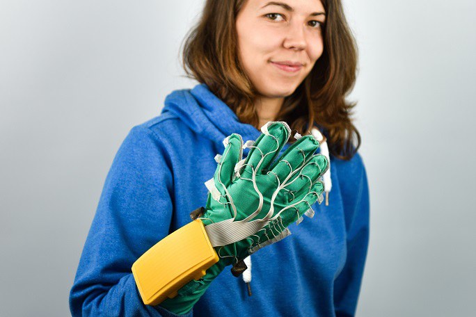 Frau mit grünem Exoskelett-Handschuh