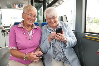 Zwei Seniorinnen mit Smartphones in der Bahn